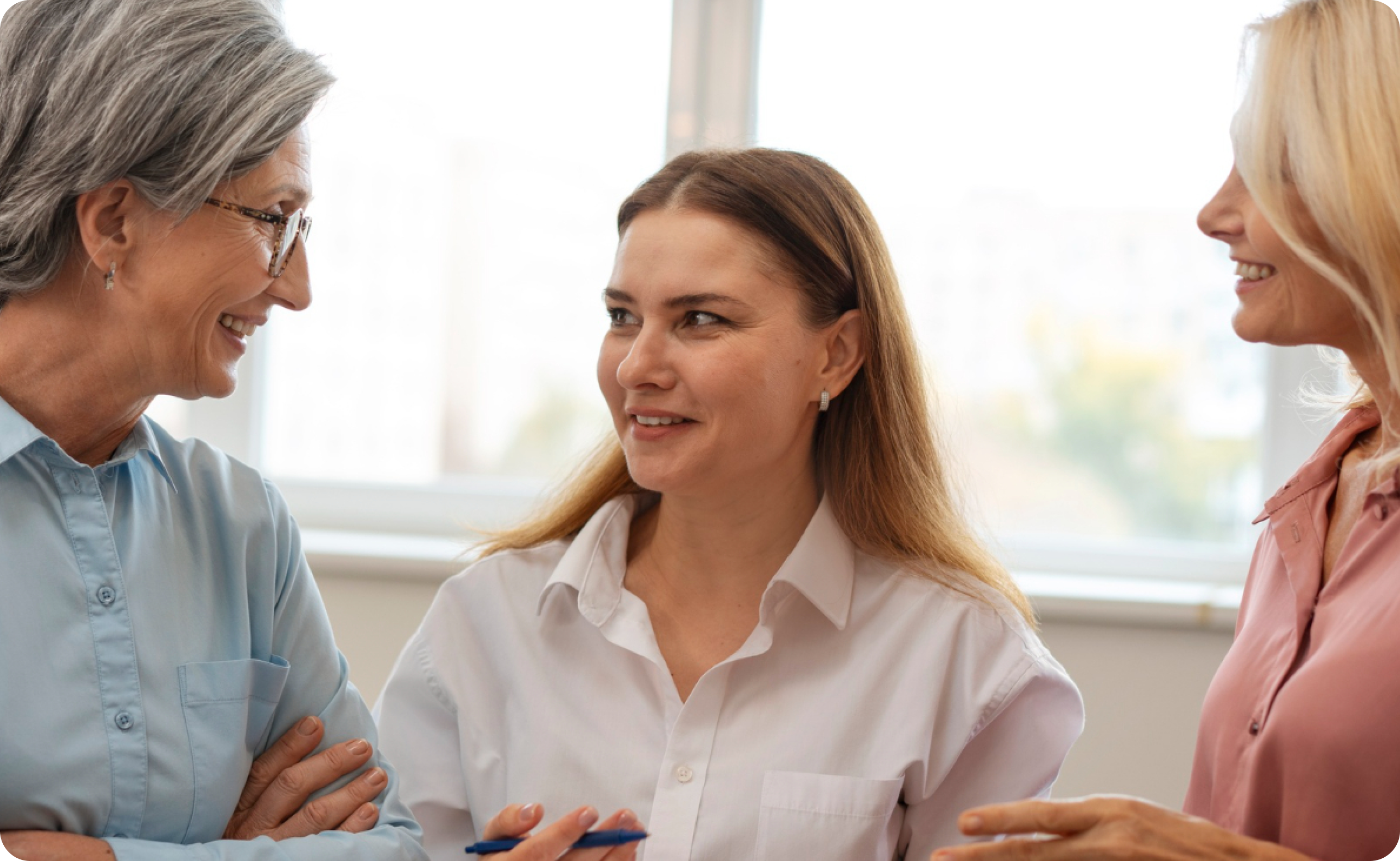 Three colleagues in conversation at a meeting table